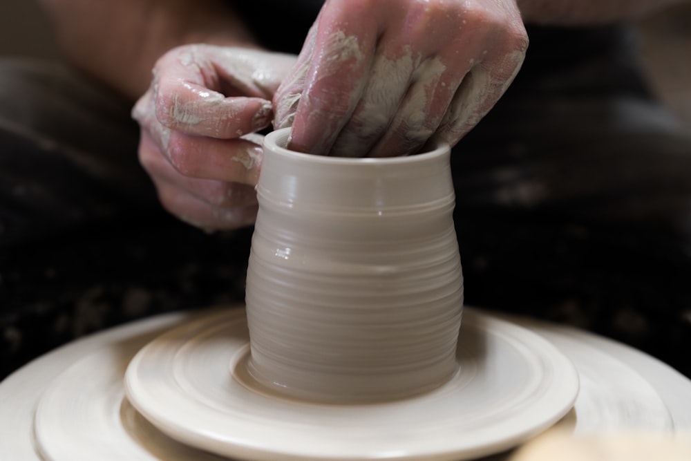 person holding round white ceramic bowl