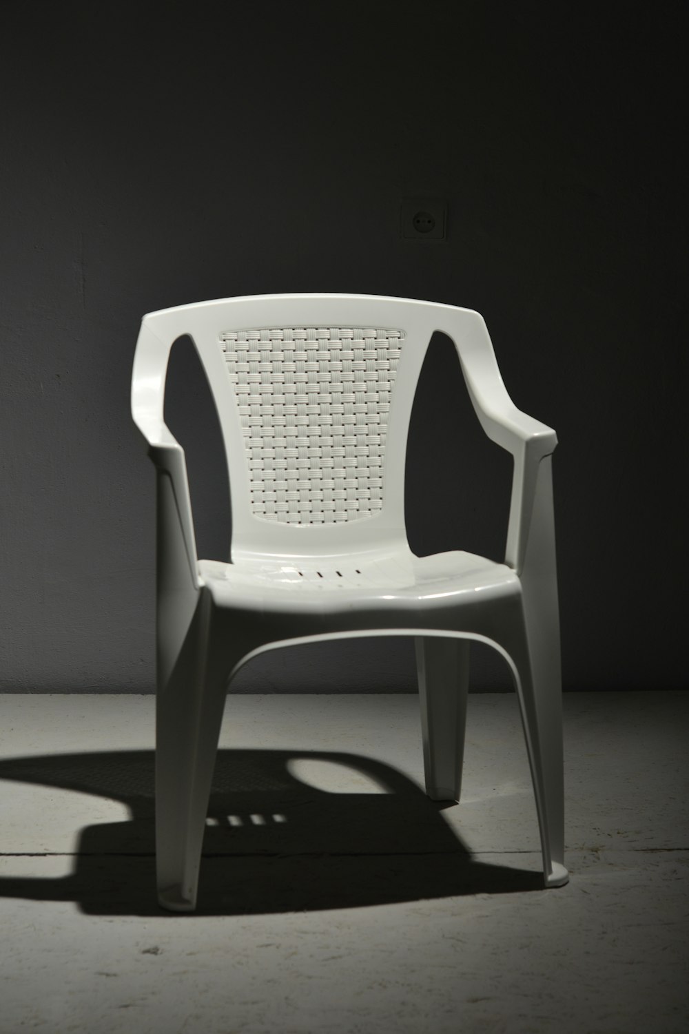 white plastic armchair on white floor
