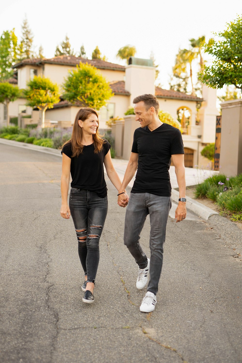 2 donne in camicie nere e leggings grigi che corrono su strada durante il giorno