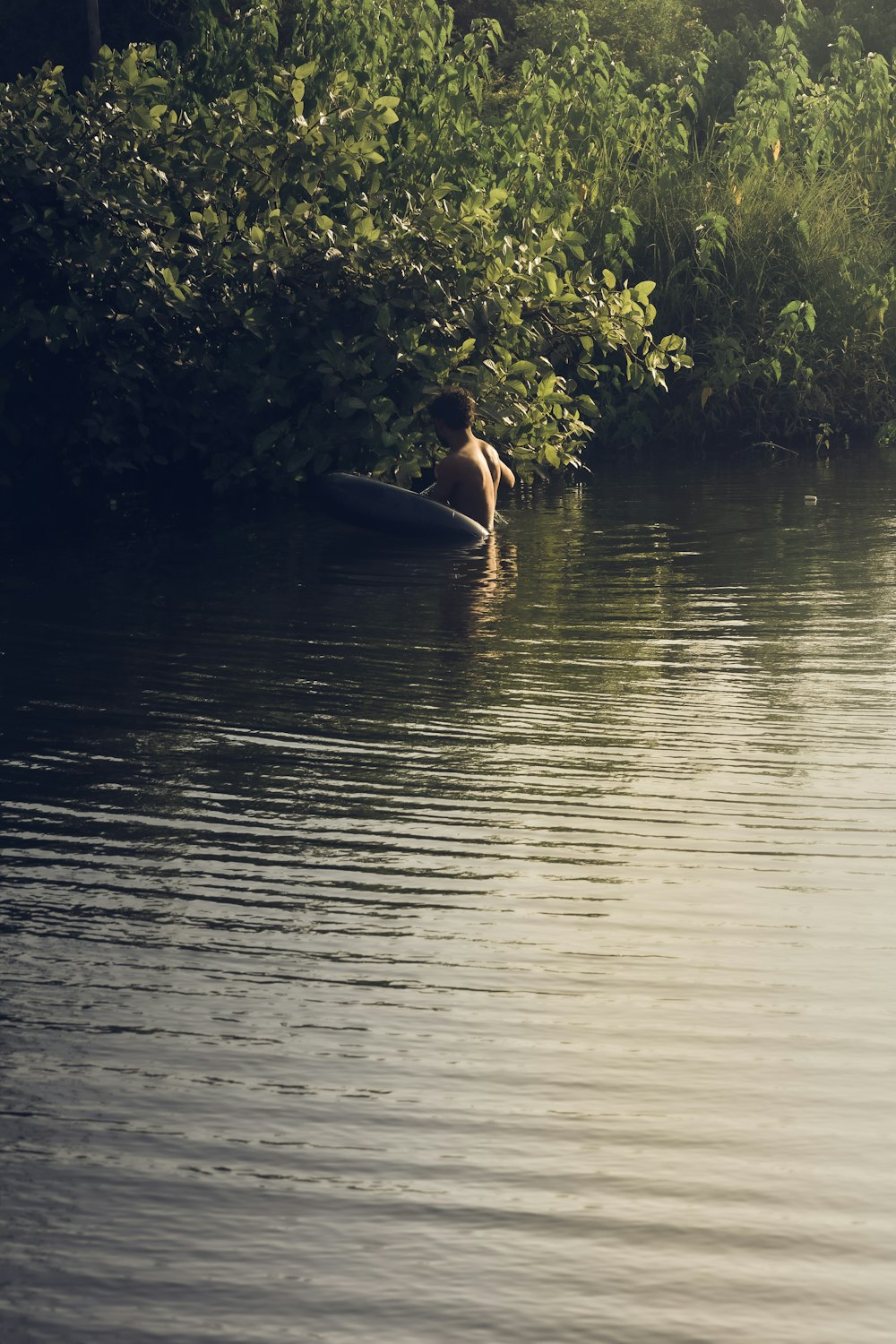 woman in black bikini on body of water during daytime