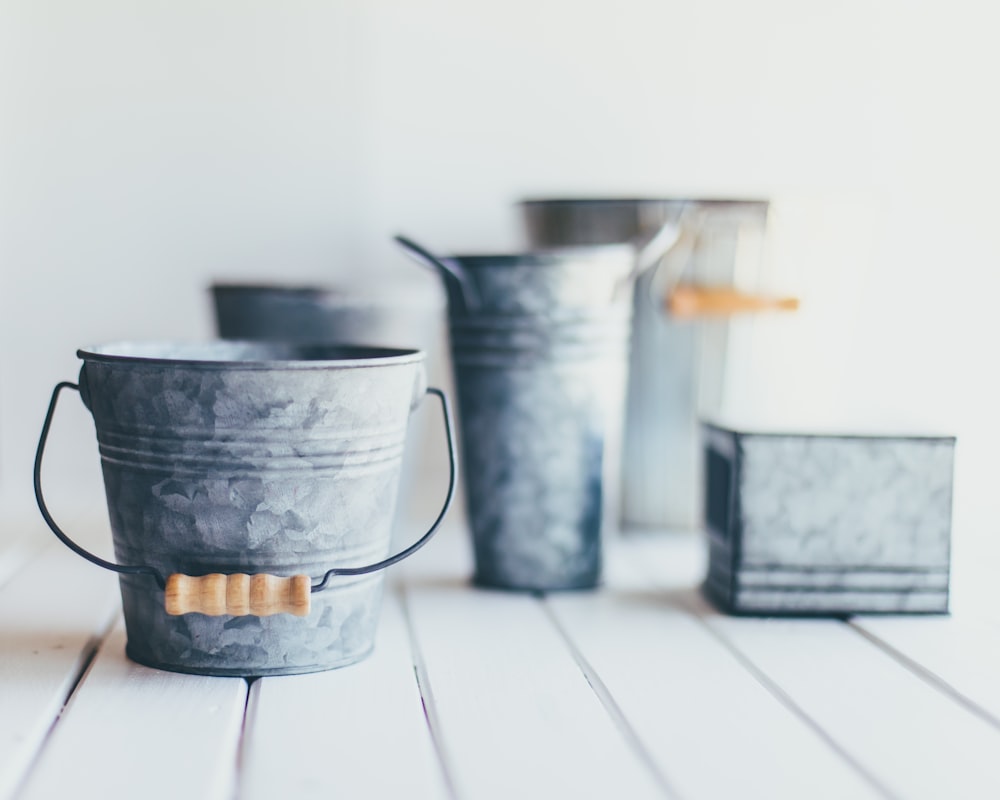 gray steel bucket on brown wooden bucket