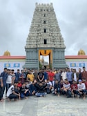 A group of travelers smiling and posing in front of a famous Indian monument