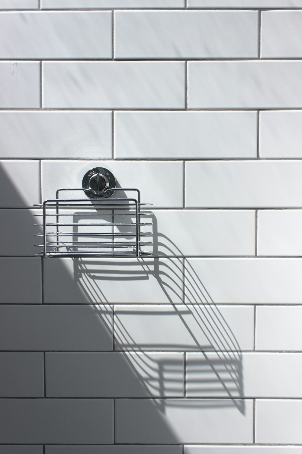 black and silver round analog watch on white ceramic wall tiles