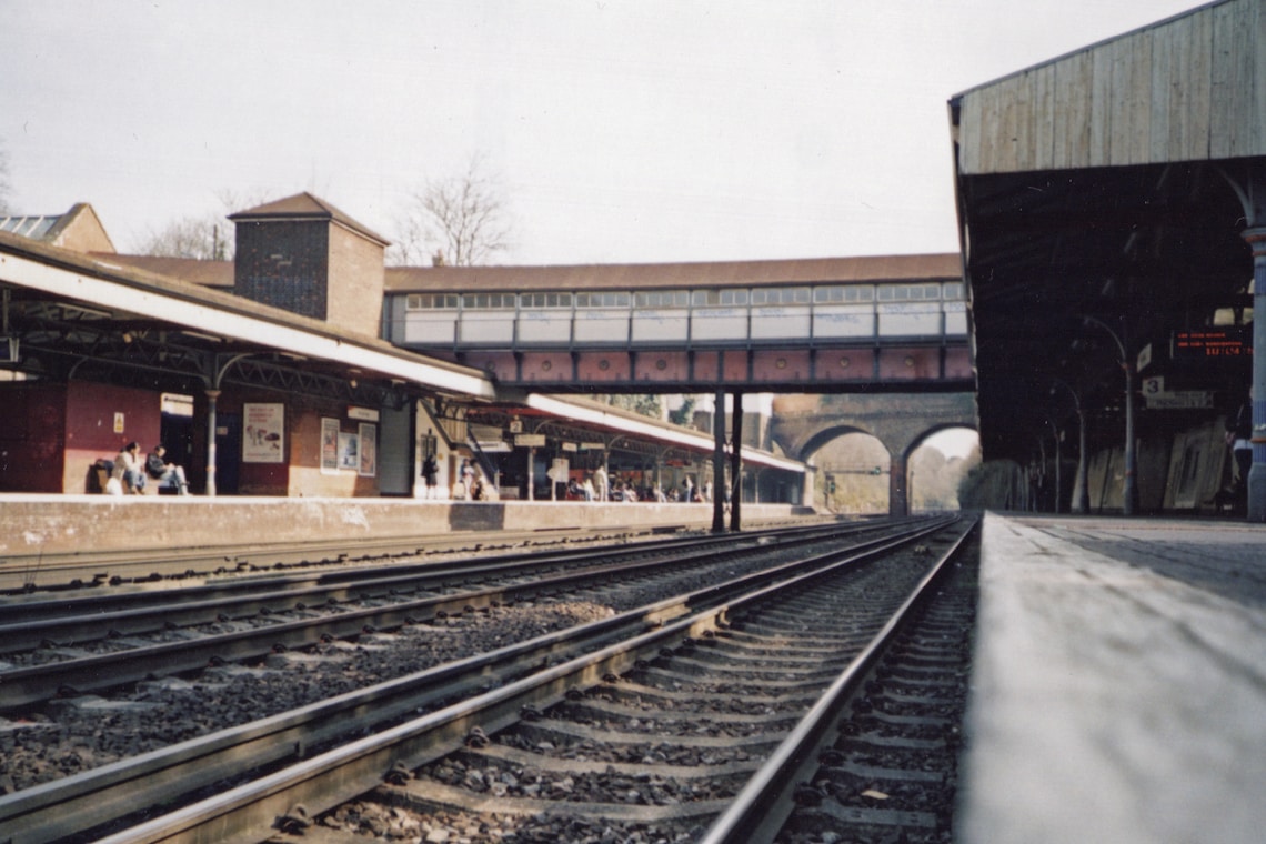 brown wooden train rail near brown concrete building during daytime