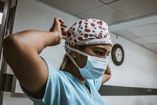 woman in teal shirt wearing white mask