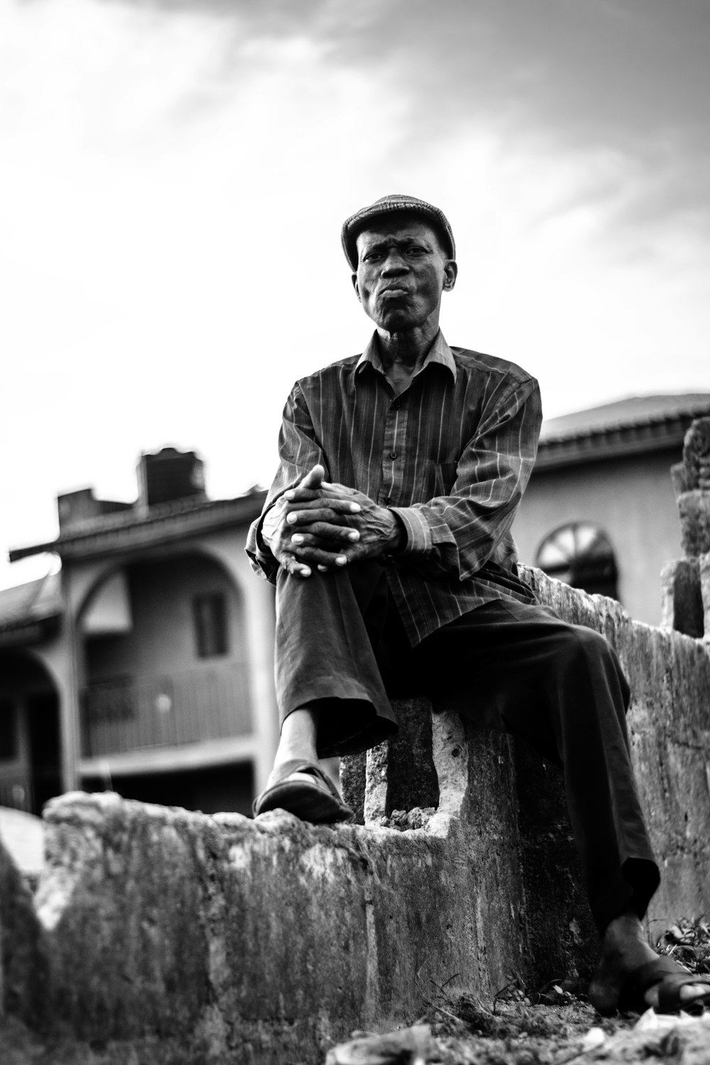 man in button up shirt sitting on concrete bench