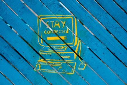 a picture of a blue and yellow sign on a wooden surface