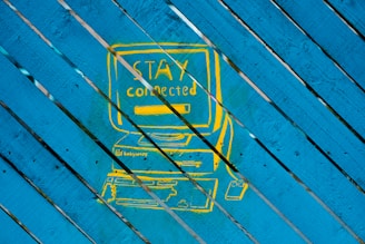 a picture of a blue and yellow sign on a wooden surface