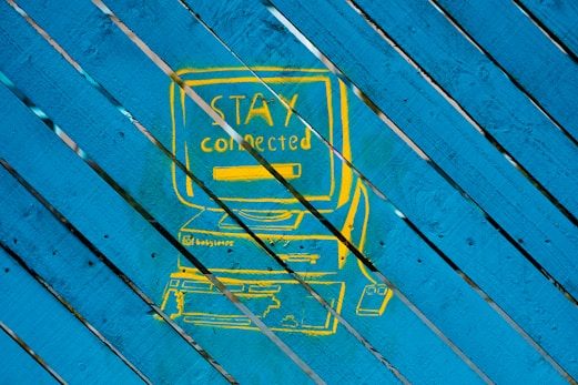 a picture of a blue and yellow sign on a wooden surface