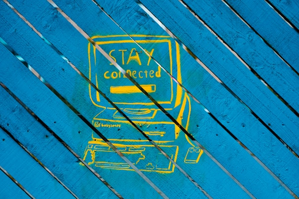 a picture of a blue and yellow sign on a wooden surface