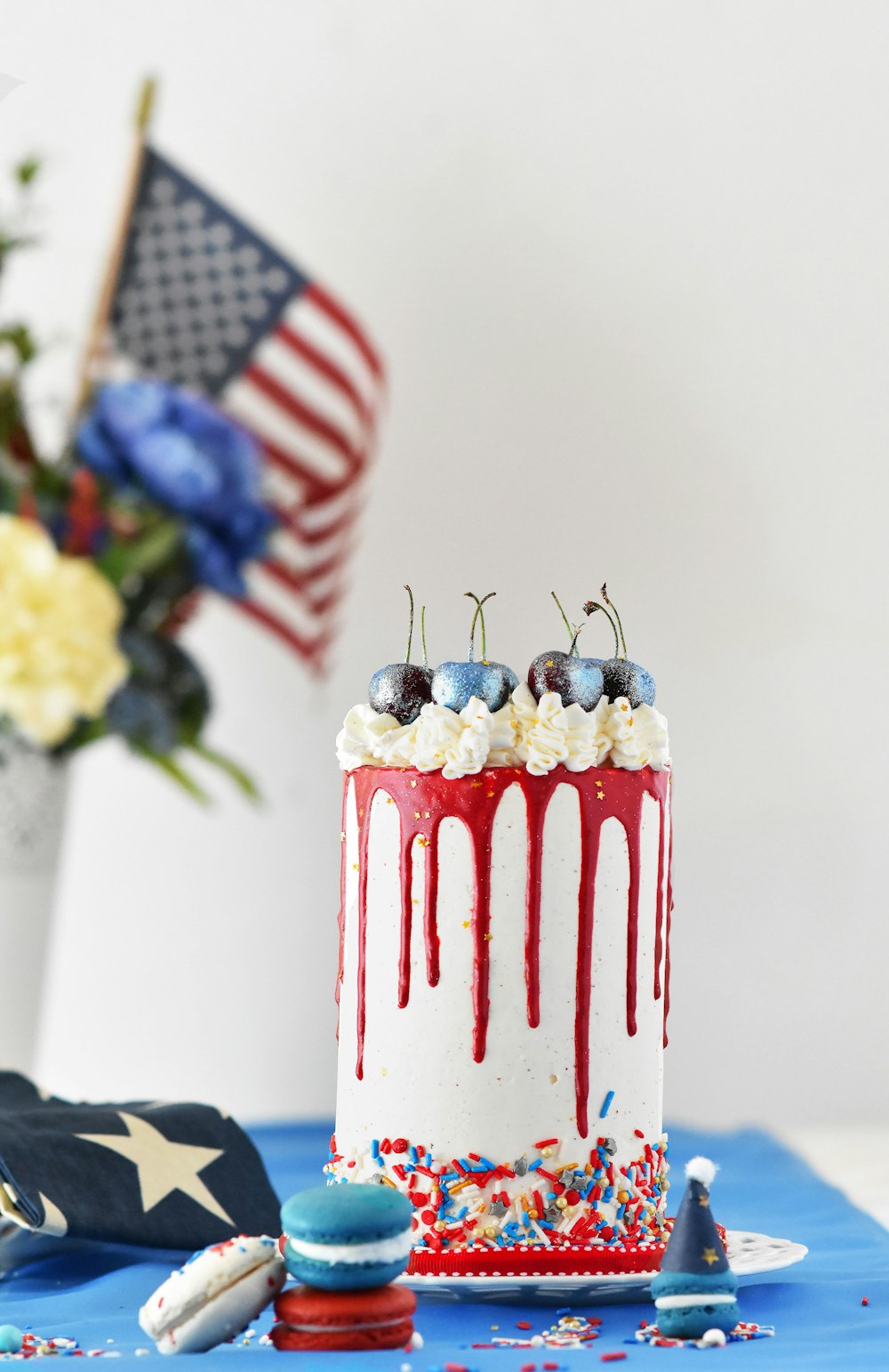 um bolo vermelho, branco e azul com cerejas e polvilhos