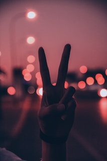 person doing peace sign hand gesture