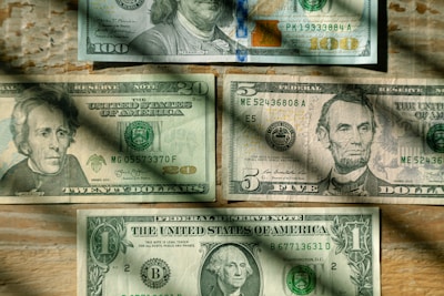 A collection of vibrant American banknotes spread out on a dark background.