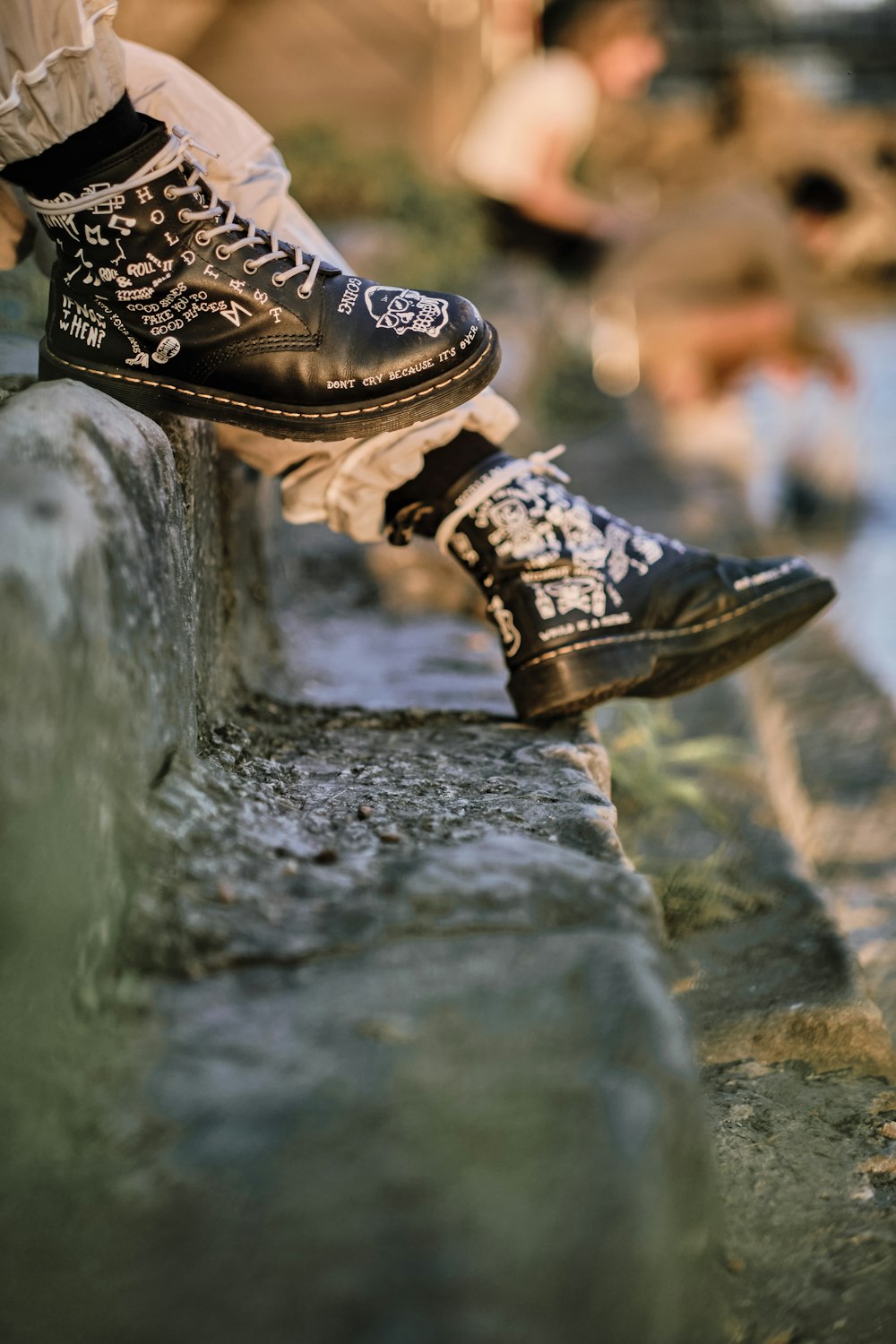 person wearing brown leather boots standing on gray concrete surface