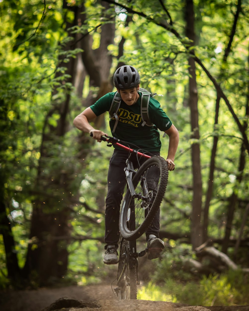 man in green and black shirt riding bicycle