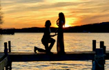 Drone shot capturing a couple sharing a proposal moment on the deck at dusk.