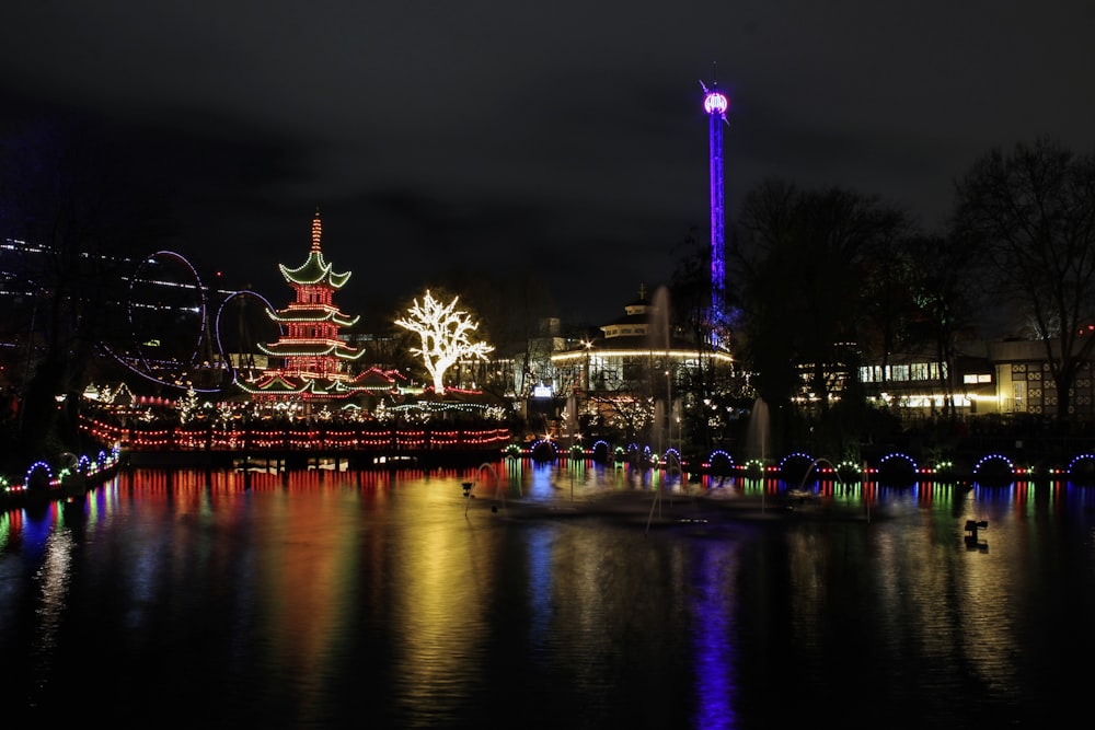 body of water near lighted building during night time