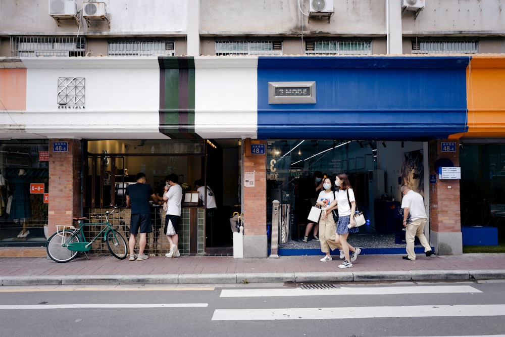 people walking on sidewalk near building during daytime