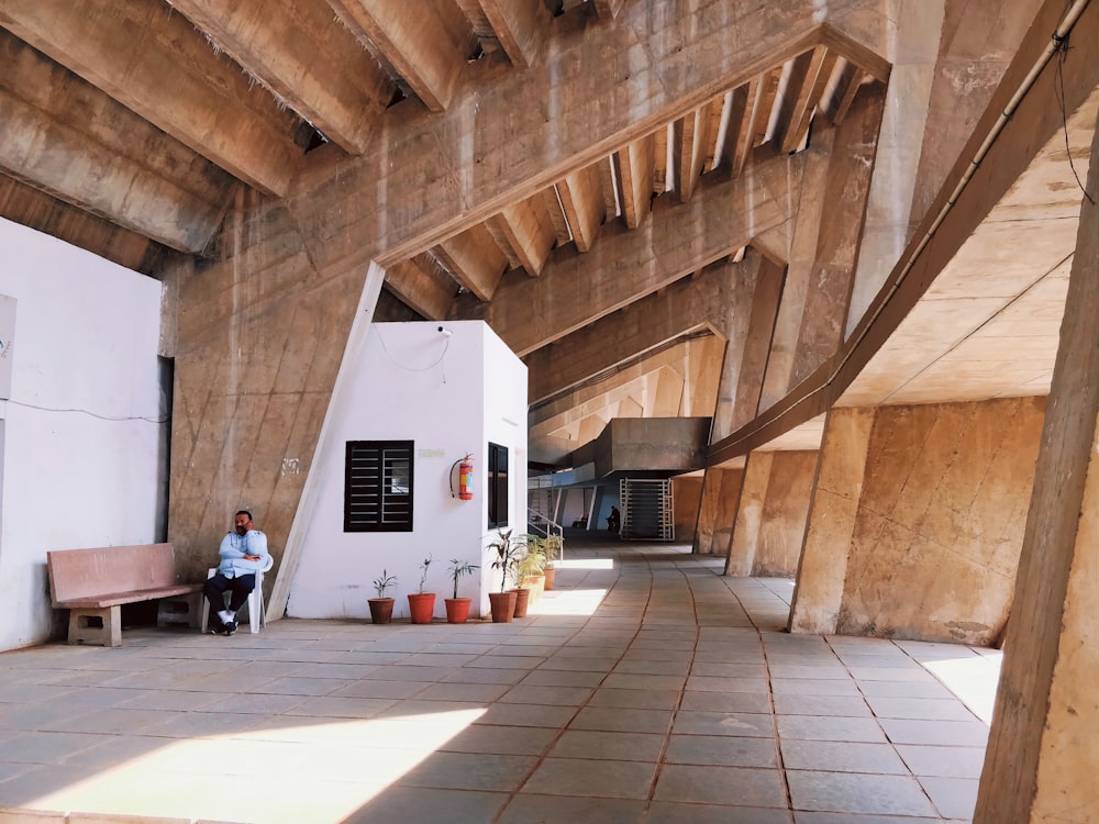 people sitting on bench near white wall