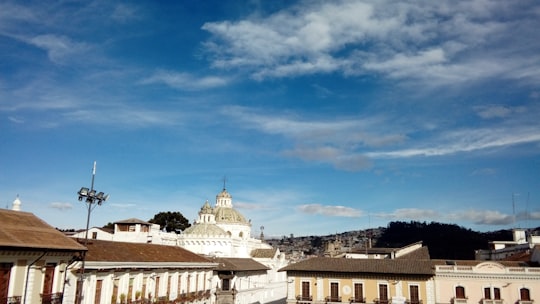 white concrete building under blue sky during daytime in Quito Ecuador