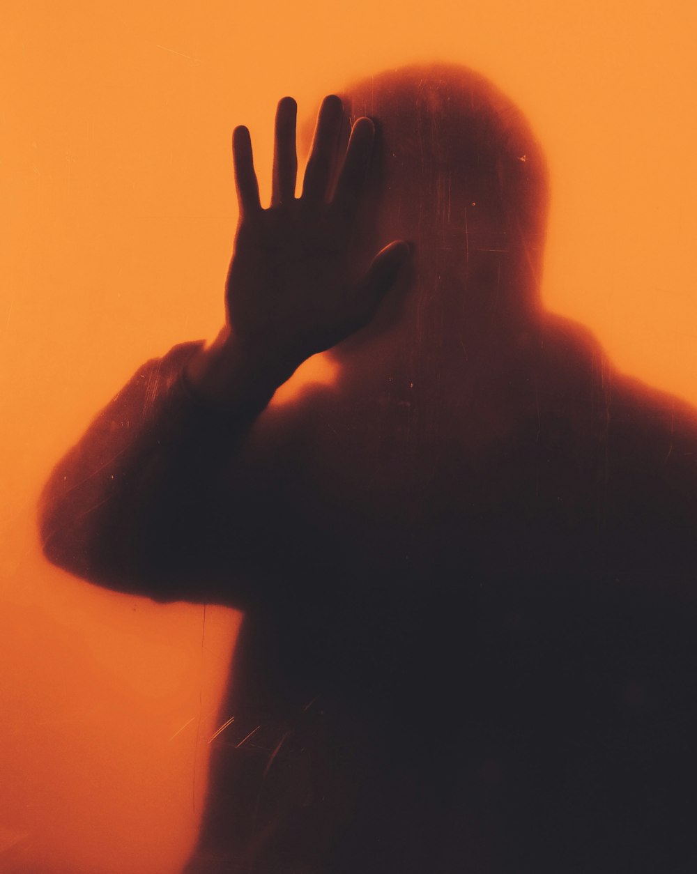 persons hand on orange background