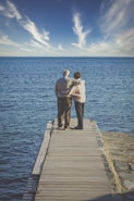 man and woman kissing on wooden dock during daytime