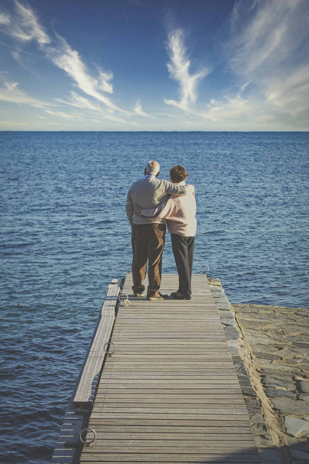 man and woman kissing on wooden dock during daytime
