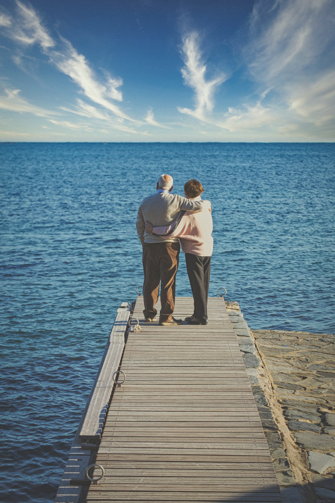 man and woman kissing on wooden dock during daytime