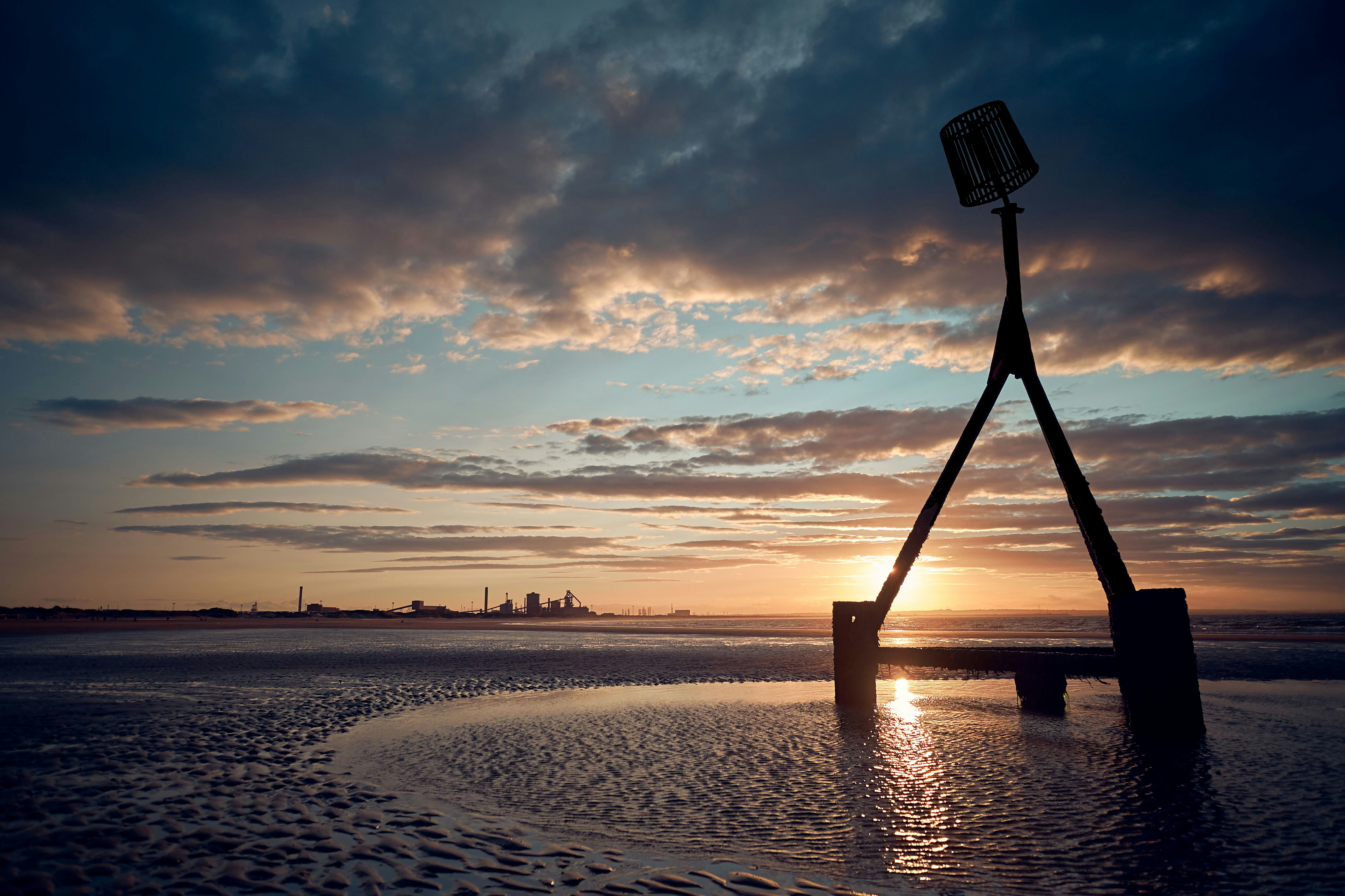 silhouette of person standing on beach during sunset
