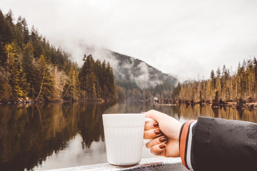 person holding white ceramic mug