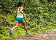 A fitness enthusiast running on a scenic trail surrounded by nature.
