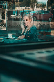A candid shot of a smiling lady enjoying a quiet moment at a stylish café terrace in Vienna.