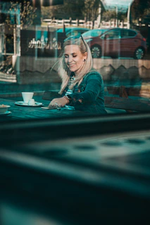 A candid shot of a smiling lady enjoying a quiet moment at a stylish café terrace in Vienna.