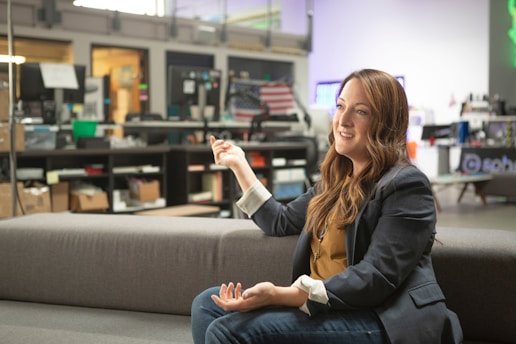 woman in black blazer sitting on gray couch