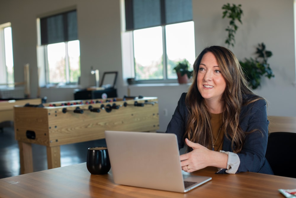 woman in brown cardigan using silver macbook