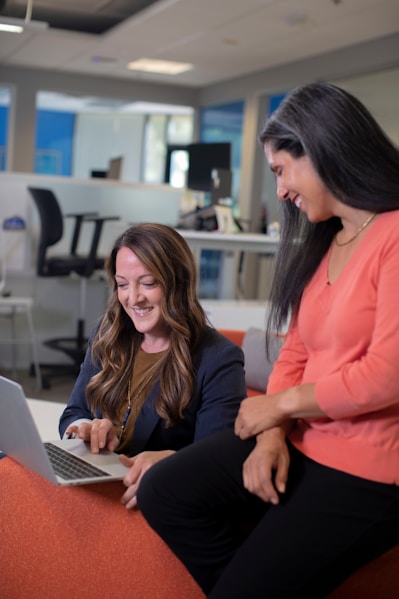 woman in pink blazer using laptop computer
