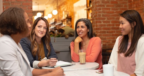 woman in black jacket sitting beside woman in white blazer