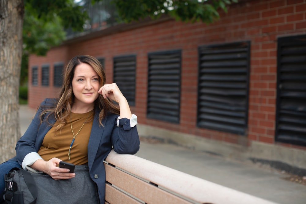 woman in black long sleeve shirt sitting on brown wooden bench