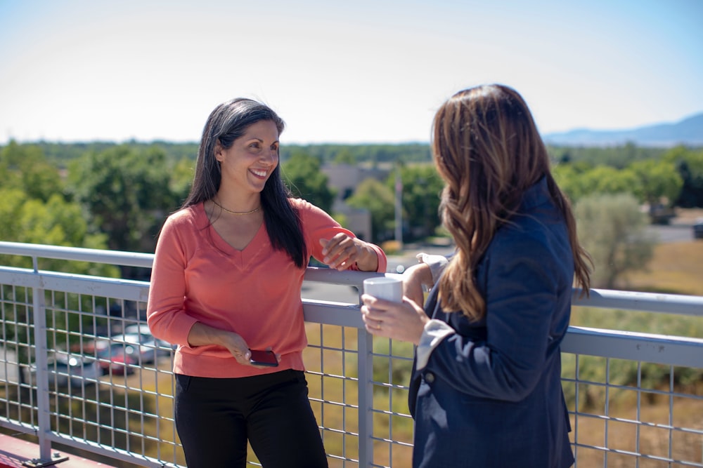 2 women standing beside railings during daytime