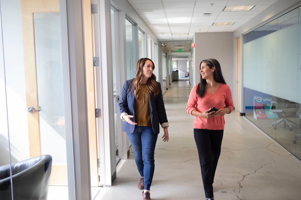 2 women standing near white wall