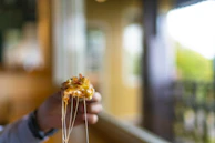 A hand lifting a slice of pizza with melted cheese stretching invitingly.