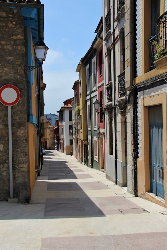 empty street in between buildings during daytime in Gijón Spain