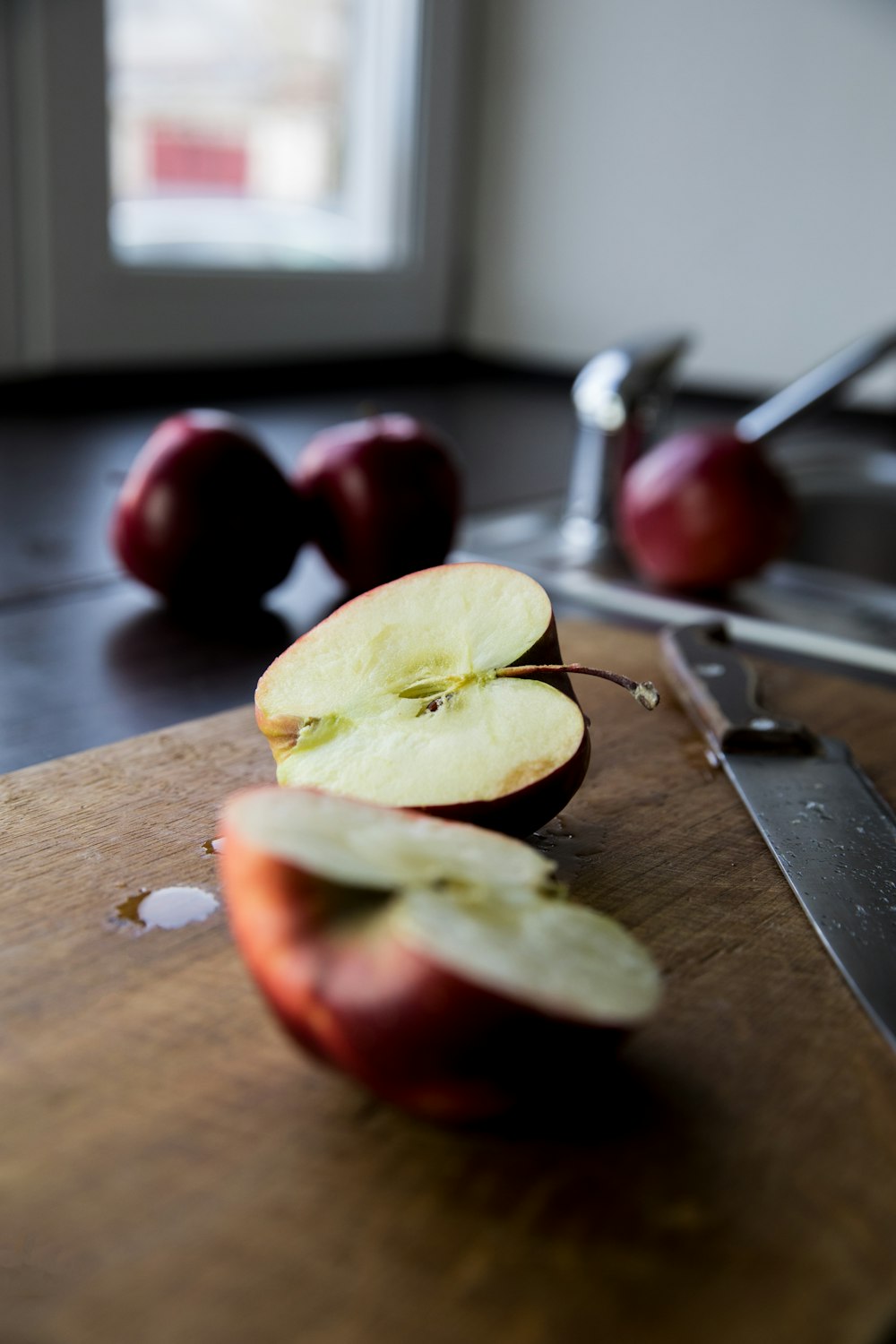 sliced apple fruit on brown wooden chopping board