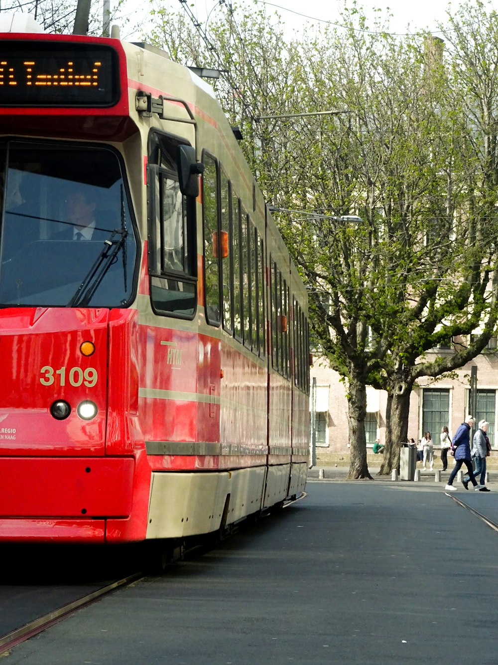 red and white tram on road during daytime