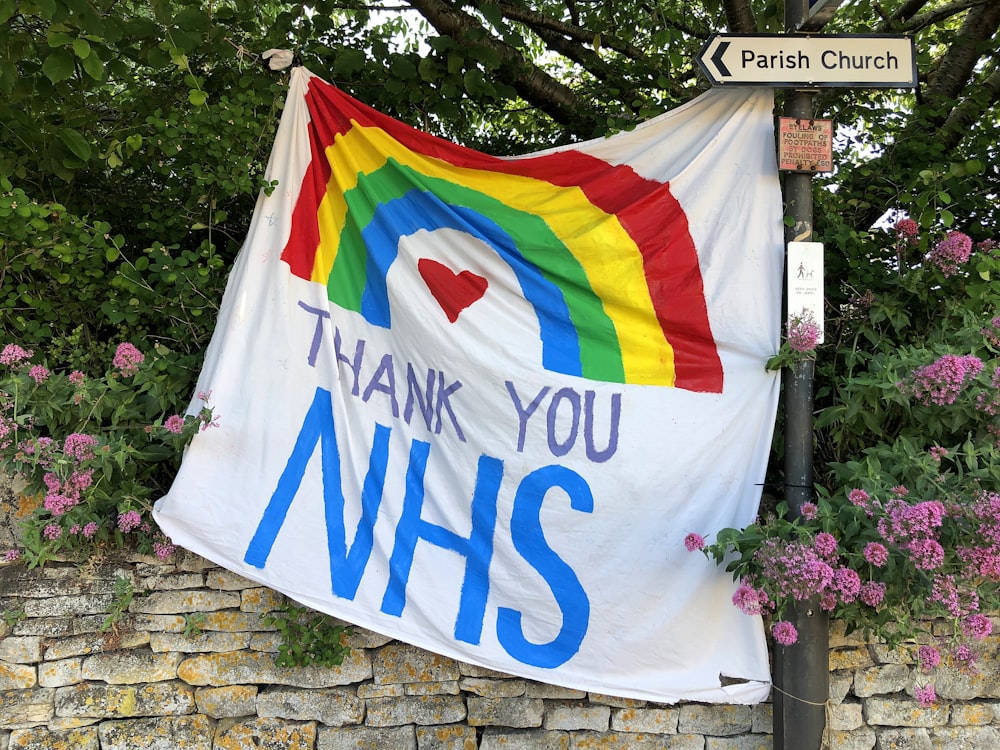 a rainbow flag hanging from a street sign