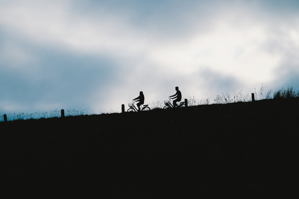 silhouette of people riding motorcycle during daytime