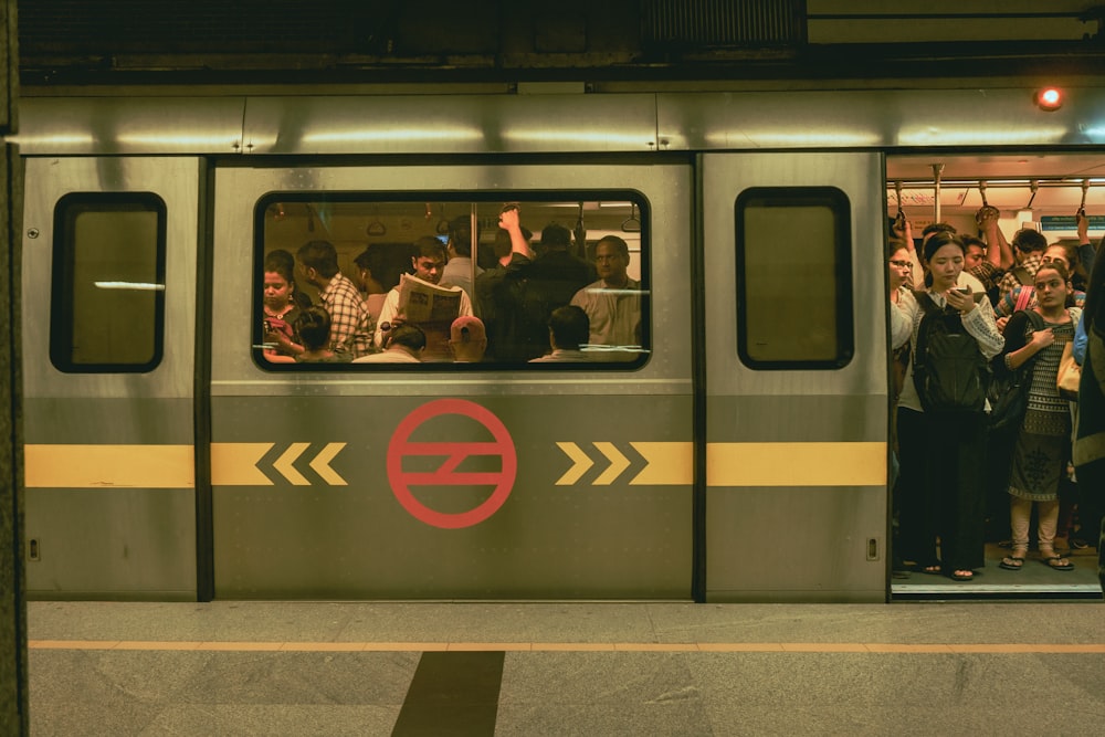 man in black jacket sitting beside yellow and red train