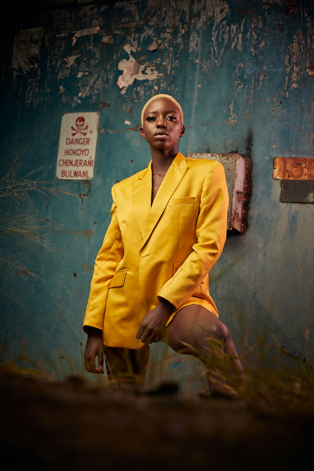 man in yellow suit jacket sitting on brown wooden seat