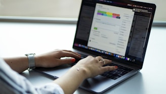 person using macbook pro on table