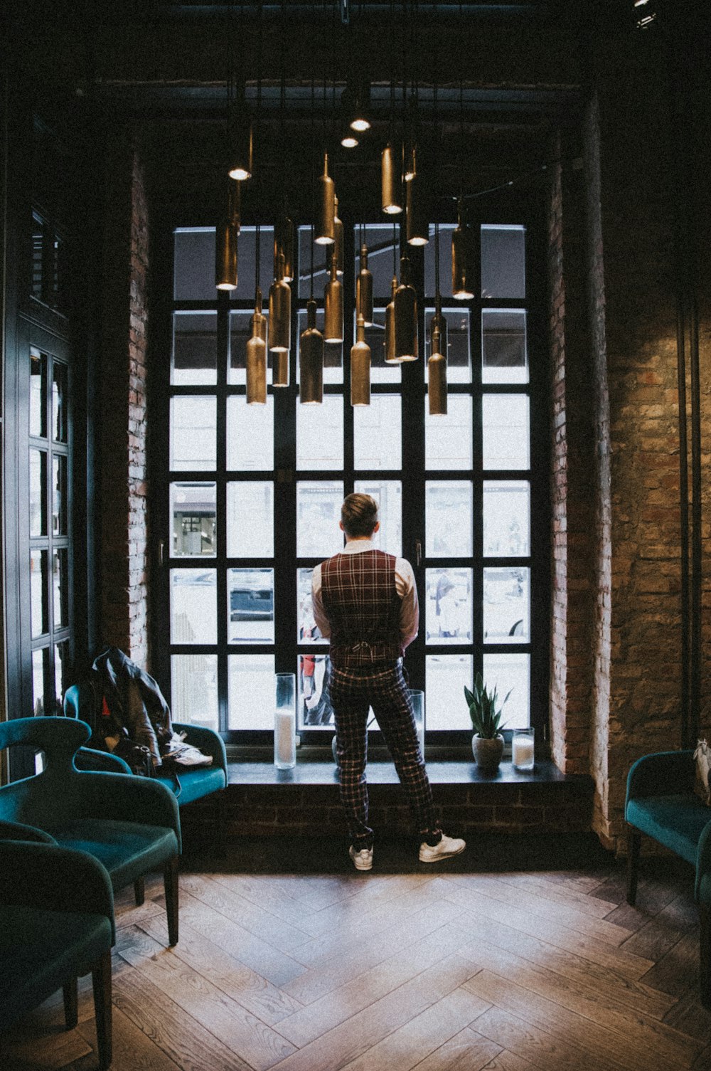 boy in white and black plaid dress shirt standing near window